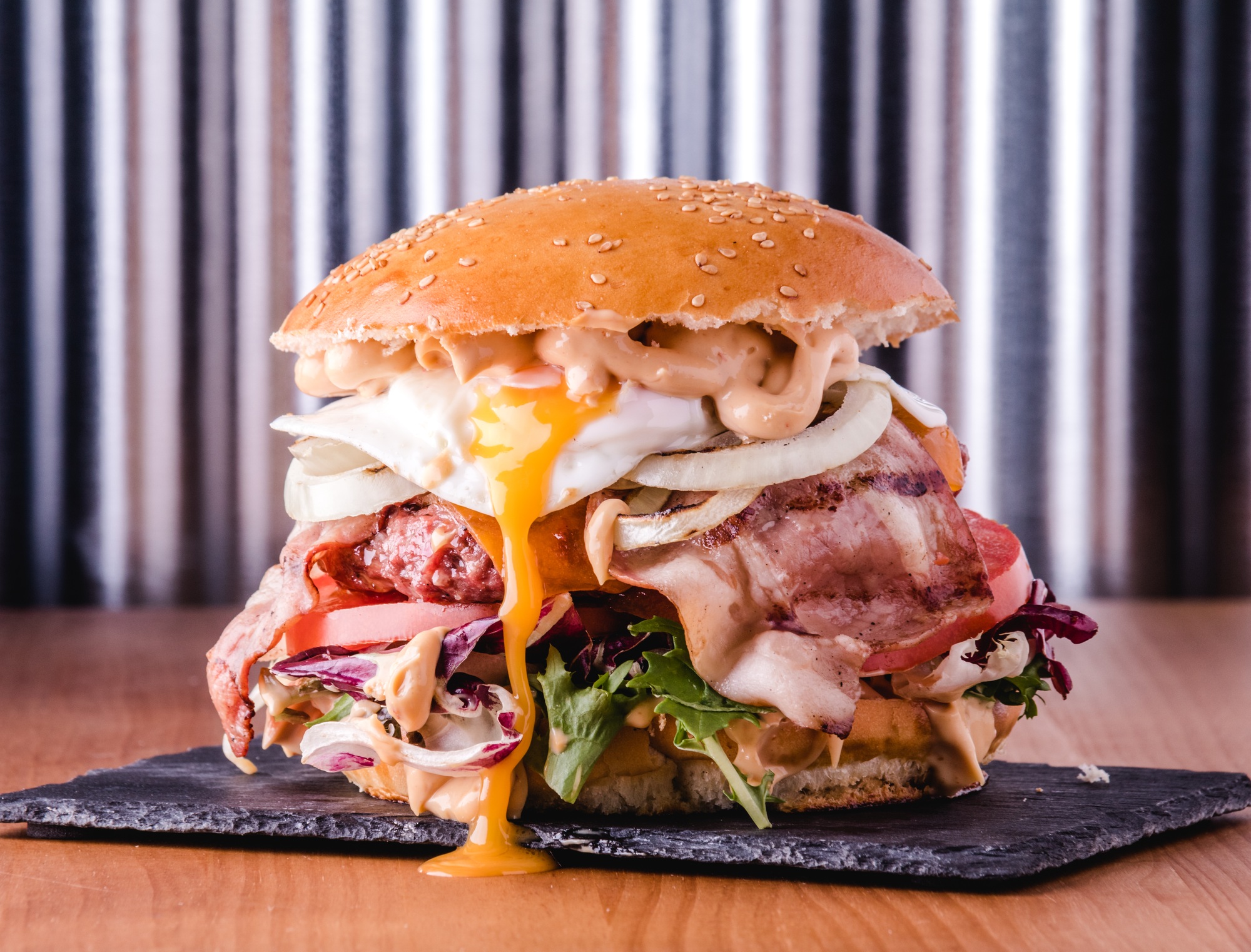 Close up view of a gourmet big burger loaded with different toppings